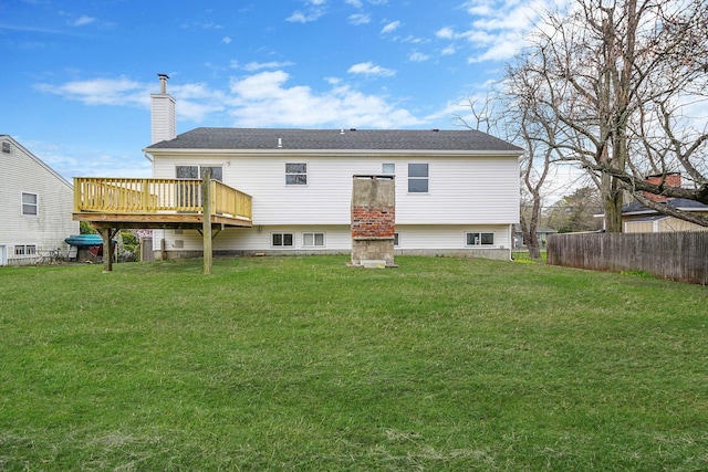 back of house featuring a yard, fence, a wooden deck, and a chimney