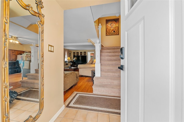 foyer entrance featuring tile patterned floors, baseboards, stairs, and ceiling fan