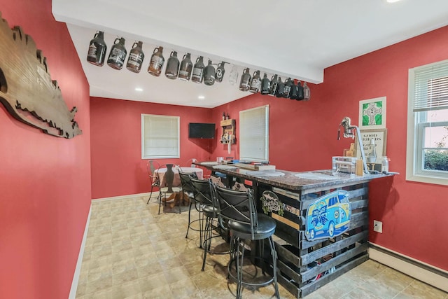 bar with a baseboard radiator, recessed lighting, and baseboards