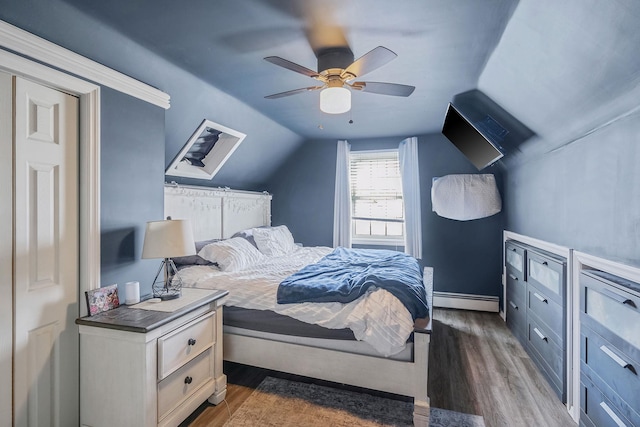 bedroom with a baseboard heating unit, dark wood-style flooring, ceiling fan, and lofted ceiling