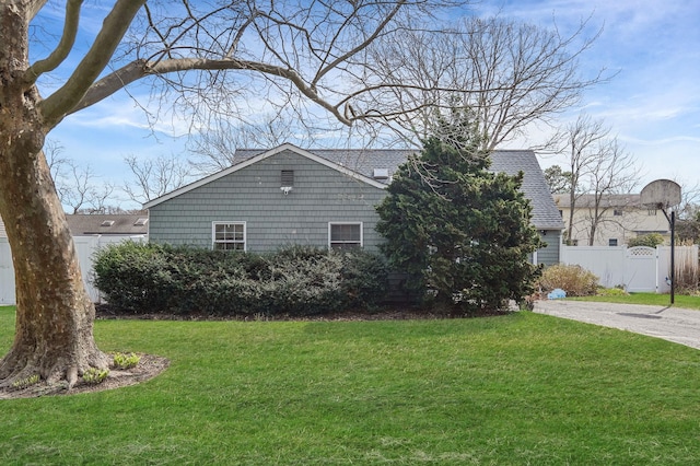 view of front of property featuring fence, driveway, and a front yard