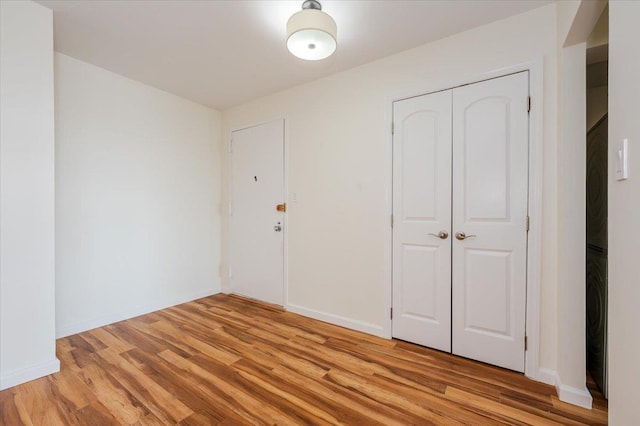 interior space featuring light wood-style flooring and baseboards
