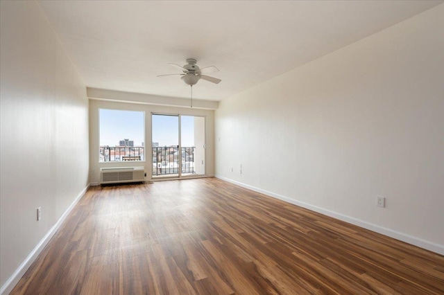 spare room featuring baseboards, ceiling fan, and wood finished floors