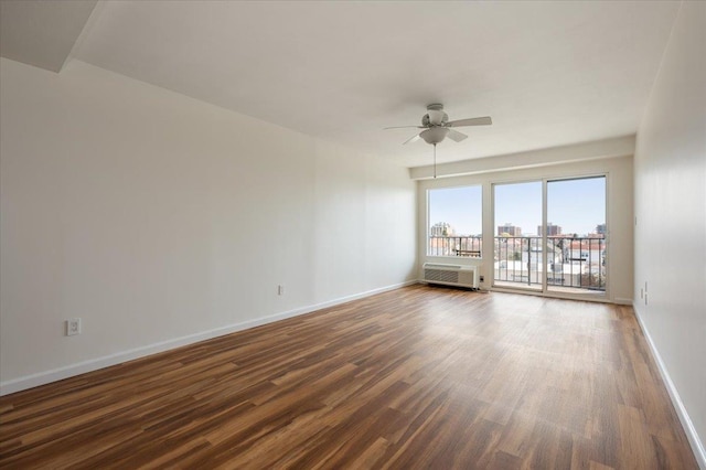 unfurnished room with baseboards, a ceiling fan, a wall mounted AC, and dark wood-style floors