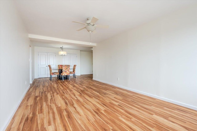unfurnished room with light wood finished floors, baseboards, and a ceiling fan