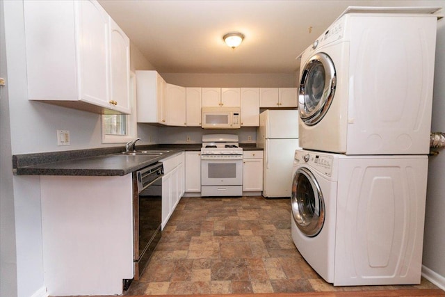 700 Sackett Lake Rd, Monticello, NY 12701 - kitchen with stacked washer and dryer, white appliances, dark countertops, stone finish flooring, and a sink