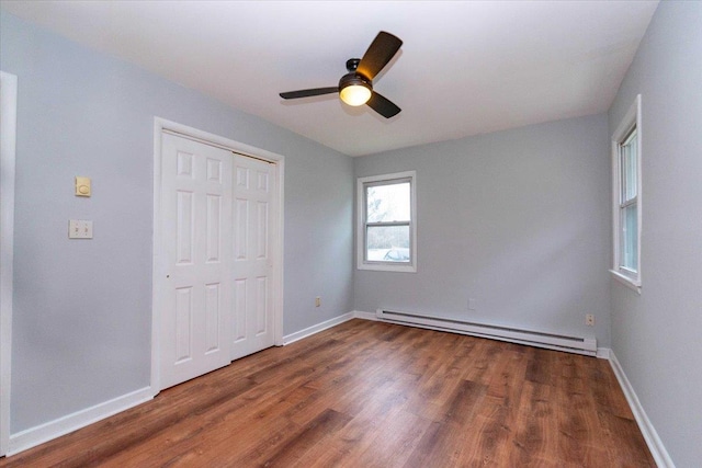 700 Sackett Lake Rd, Monticello, NY 12701 - unfurnished bedroom with a closet, baseboards, a baseboard heating unit, and wood finished floors