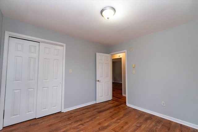 700 Sackett Lake Rd, Monticello, NY 12701 - unfurnished bedroom with a closet, baseboards, and wood finished floors
