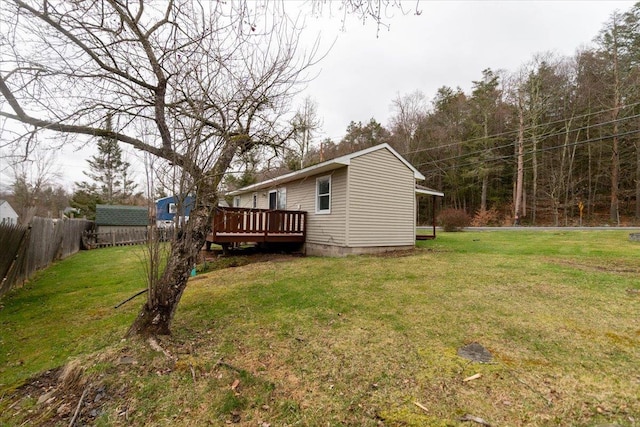 700 Sackett Lake Rd, Monticello, NY 12701 - rear view of house featuring a yard, a deck, an outdoor structure, and fence