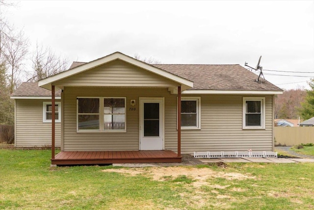 700 Sackett Lake Rd, Monticello, NY 12701 - back of house featuring roof with shingles, fence, and a lawn