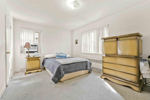 bedroom featuring carpet floors, radiator heating unit, and multiple windows