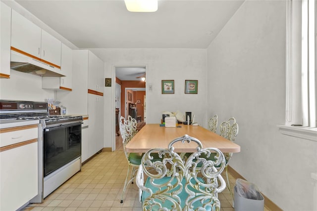 kitchen with white cabinets, white electric range, under cabinet range hood, light countertops, and baseboards