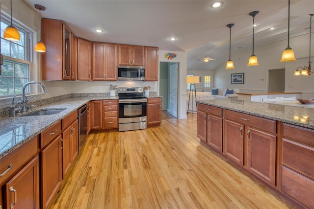 555 Three Waters Ln, Orient, NY 11957 - kitchen with light wood-style flooring, appliances with stainless steel finishes, brown cabinetry, and a sink
