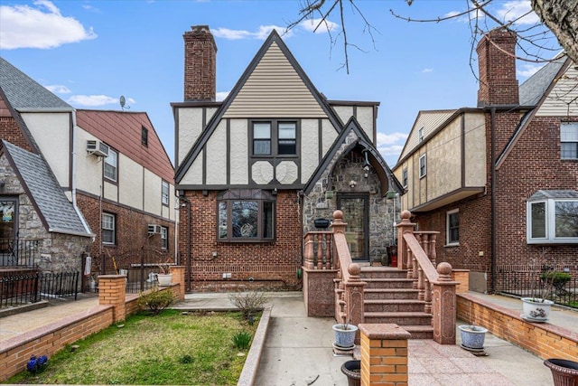 view of front of house featuring stucco siding, a chimney, stone siding, a wall unit AC, and fence