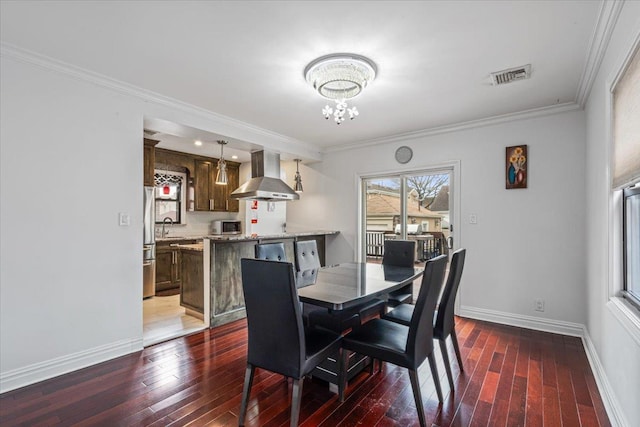 dining space with a notable chandelier, baseboards, ornamental molding, visible vents, and hardwood / wood-style floors