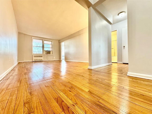 60-11 Broadway Unit 4C, Woodside, NY 11377 - unfurnished room featuring radiator heating unit, light wood-style floors, and baseboards