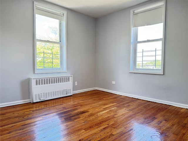 60-11 Broadway Unit 4C, Woodside, NY 11377 - empty room featuring radiator, wood finished floors, and baseboards