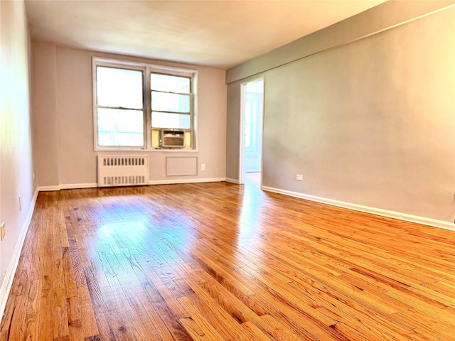 60-11 Broadway Unit 4C, Woodside, NY 11377 - spare room with radiator heating unit, wood-type flooring, baseboards, and cooling unit