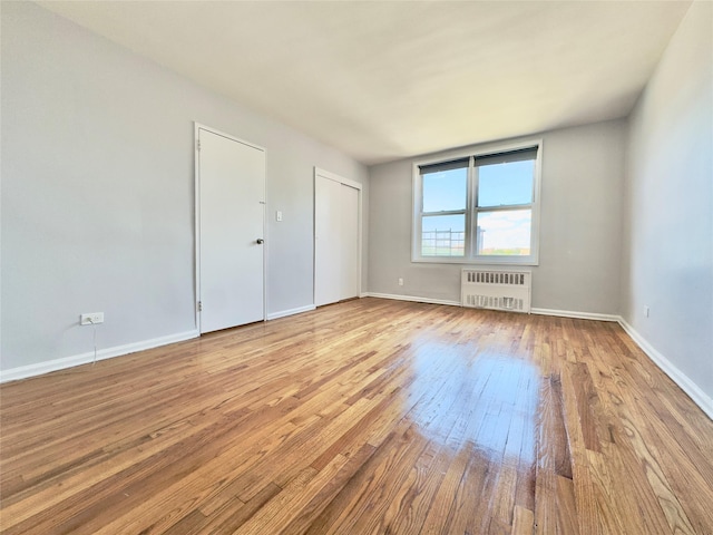 60-11 Broadway Unit 4C, Woodside, NY 11377 - spare room featuring radiator heating unit, hardwood / wood-style floors, and baseboards