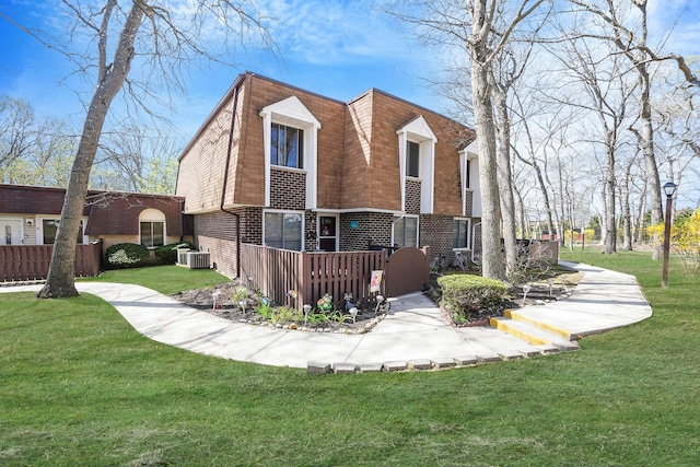 view of property exterior featuring a yard, central AC, brick siding, a deck, and mansard roof