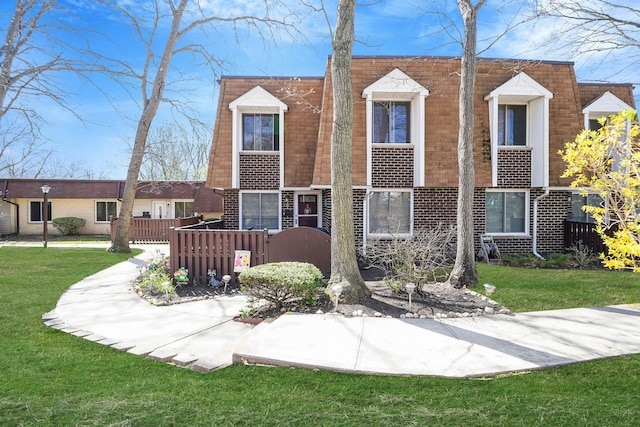 view of front of property featuring a front lawn and brick siding