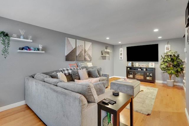 living room with recessed lighting, light wood-style flooring, and baseboards