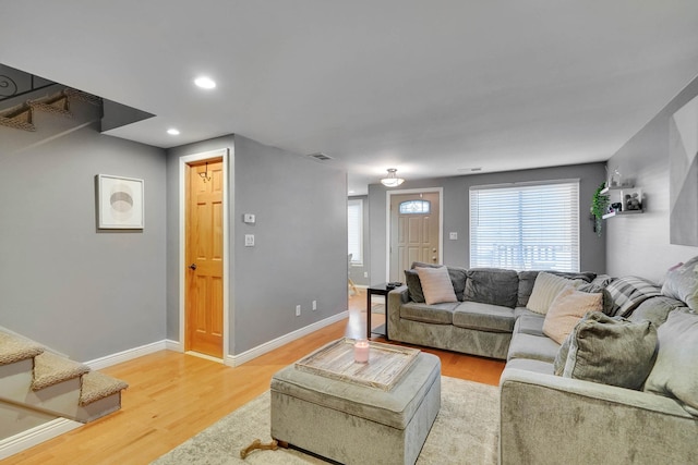 living room featuring light wood finished floors, visible vents, and baseboards