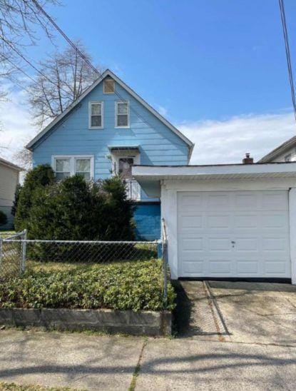 2933 Tenbroeck Ave, Bronx, NY 10469 - view of front facade with an attached garage, fence, and concrete driveway