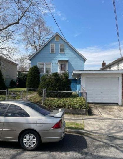 2933 Tenbroeck Ave, Bronx, NY 10469 - view of front facade featuring an attached garage, fence, a gate, and driveway