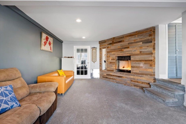31 Arthur St, Baldwin, NY 11510 - carpeted living area with recessed lighting, an accent wall, a stone fireplace, and wood walls