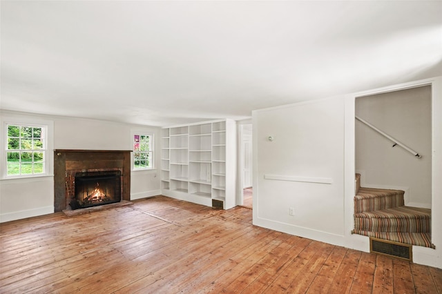 100 E St, South Salem, NY 10590 - unfurnished living room with a warm lit fireplace, wood-type flooring, and stairs