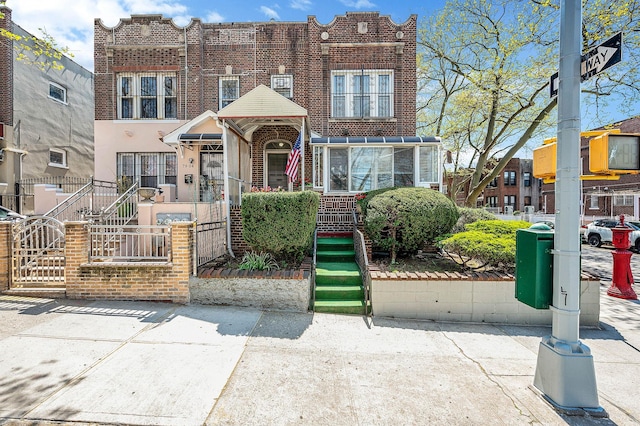 townhome / multi-family property with brick siding and a fenced front yard