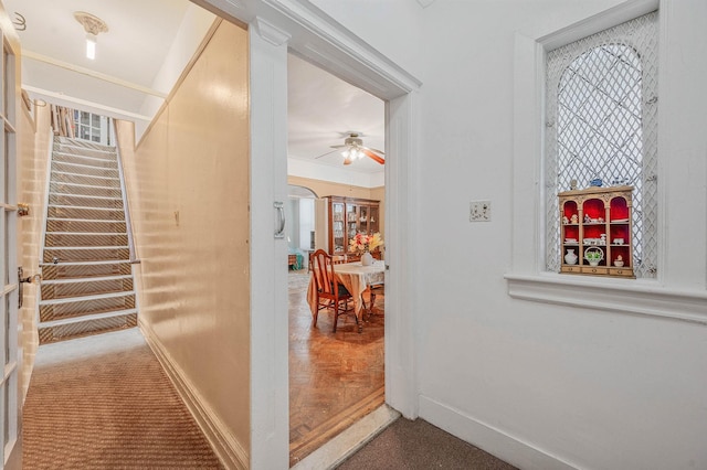 hall with arched walkways, baseboards, carpet, and crown molding