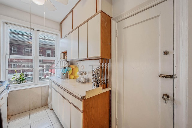 kitchen featuring ceiling fan, light tile patterned floors, light countertops, and plenty of natural light