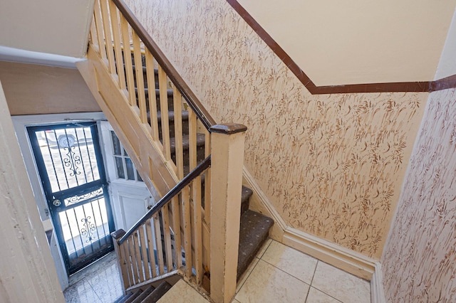 stairway featuring tile patterned floors and wallpapered walls