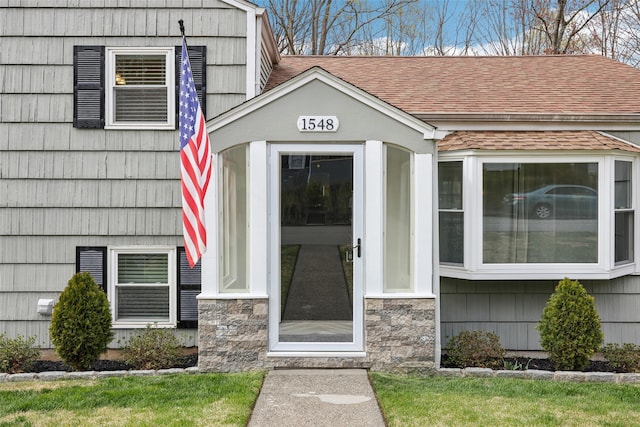 property entrance with a shingled roof