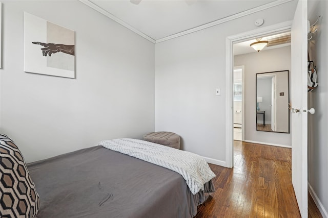 bedroom with crown molding, baseboards, and dark wood-style floors