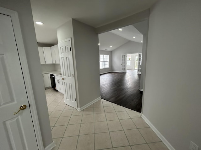 hall with light tile patterned floors, baseboards, recessed lighting, and lofted ceiling