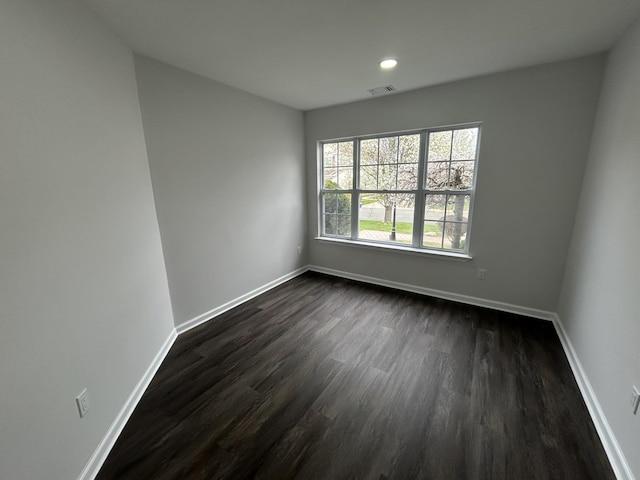 empty room with visible vents, baseboards, recessed lighting, and dark wood-style floors