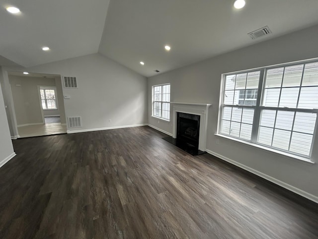 unfurnished living room with visible vents, vaulted ceiling, and dark wood finished floors