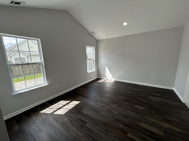 empty room featuring baseboards, vaulted ceiling, and a wealth of natural light
