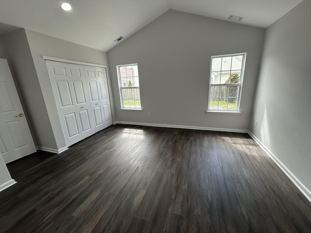 unfurnished bedroom with vaulted ceiling, multiple windows, and visible vents