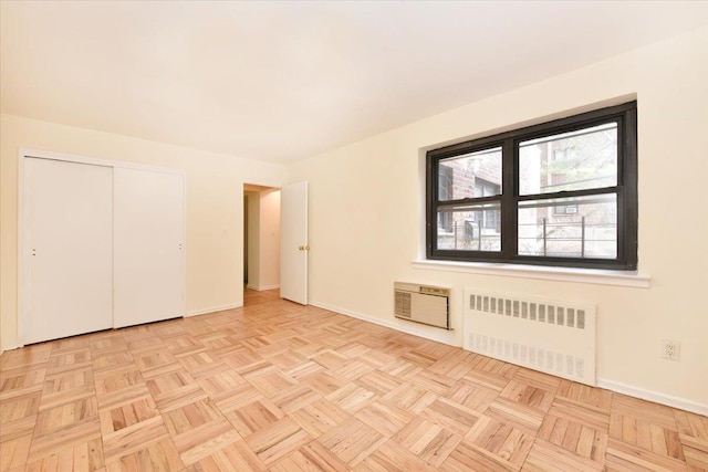 interior space with a wall mounted air conditioner, baseboards, and radiator