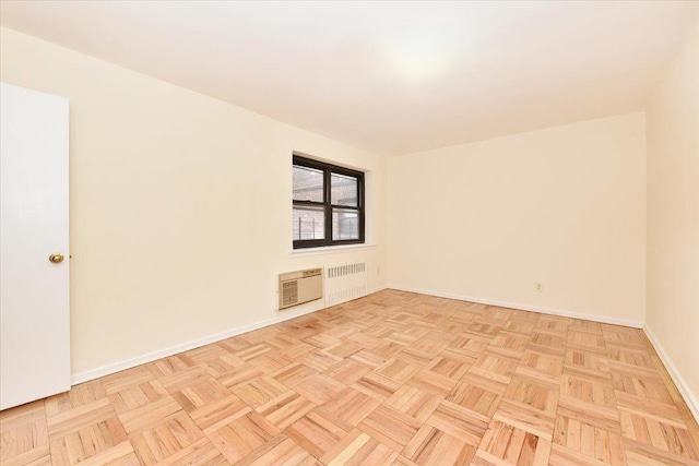 spare room with baseboards and radiator