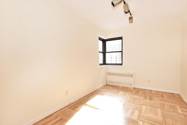 empty room featuring baseboards and radiator