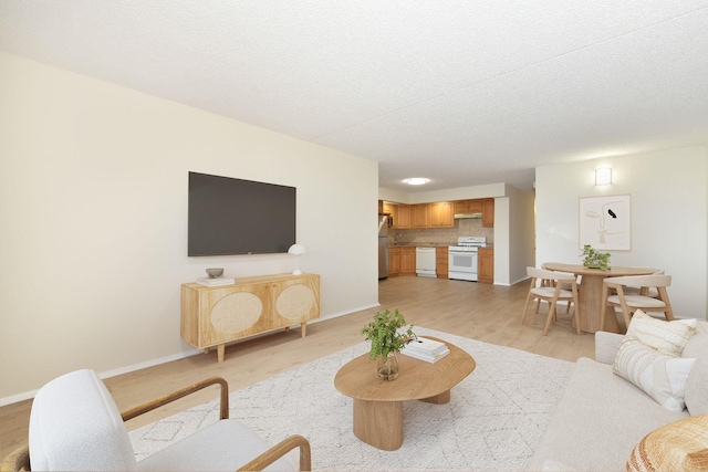 living area with baseboards and light wood-type flooring