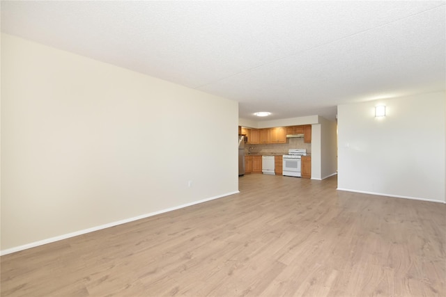unfurnished living room featuring baseboards and light wood-type flooring