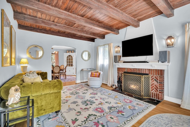 living room with arched walkways, wooden ceiling, wood finished floors, and a fireplace