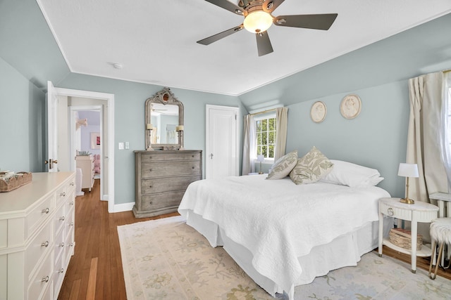 bedroom featuring ceiling fan, wood finished floors, lofted ceiling, and a closet