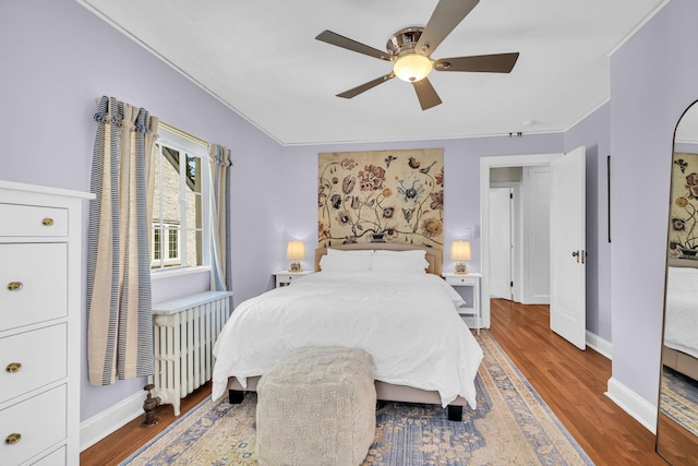 bedroom with baseboards, a ceiling fan, crown molding, and wood finished floors